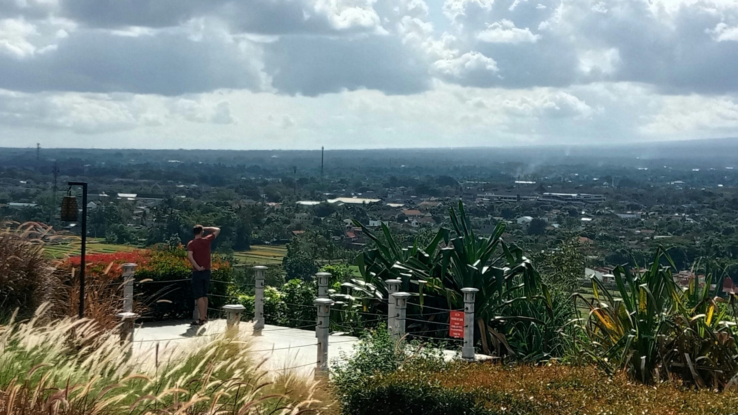 a man standing on a man standing on top of a lush green hillside